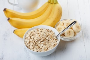 25057874 - bowl of oat flakes with sliced banana close-up on wooden table